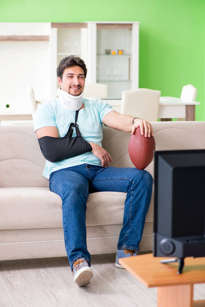 Homme avec blessure au cou et au bras regarder le football américain à la télévision - Photo, image