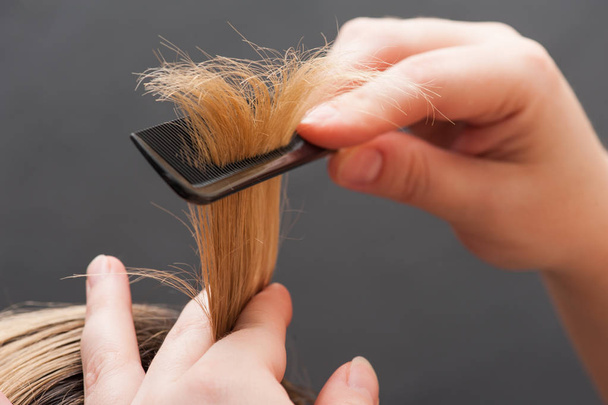 Peinar el cabello rubio con cepillo, primer plano
 - Foto, imagen