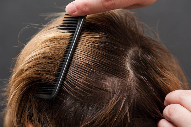 Peinar el cabello rubio con cepillo, primer plano
 - Foto, Imagen