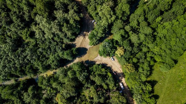 Vista aérea de cima para baixo das montanhas do Cáucaso Floresta Árvores e estrada. Diretamente acima vista de drone em um dia ensolarado de verão
. - Foto, Imagem