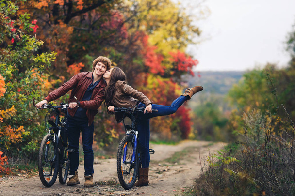 göndör hajú, bajuszos fickó egy érc-hajú lány az őszi állni a kerékpár út és vidám érzelmek megjelenítése. - Fotó, kép
