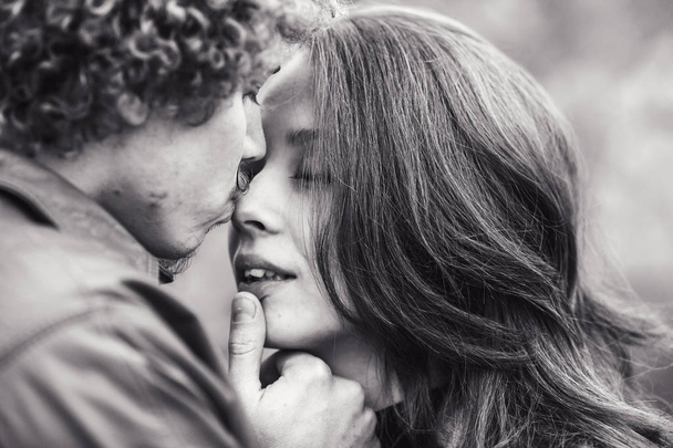 Curly-haired mustachioed man and brown-haired woman hugging in autumn. - Photo, Image