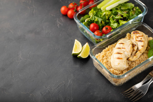 Healthy meal prep containers with quinoa, chicken breast and green salad overhead shot with copy space. - Photo, Image