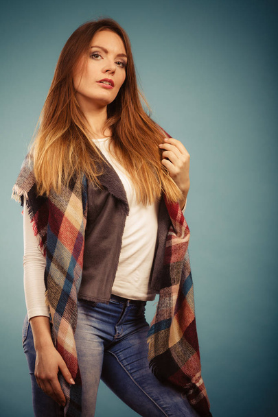 Autumnal look concept. Fashionable young woman wearing warm autumn clothing woolen checked scarf, denim pants - Valokuva, kuva
