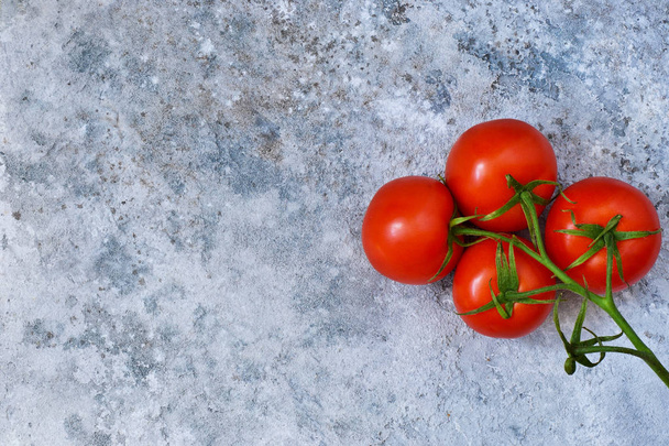 Rama de tomate sobre el fondo de piedra. Fondo alimentario con lugar para el texto
. - Foto, imagen