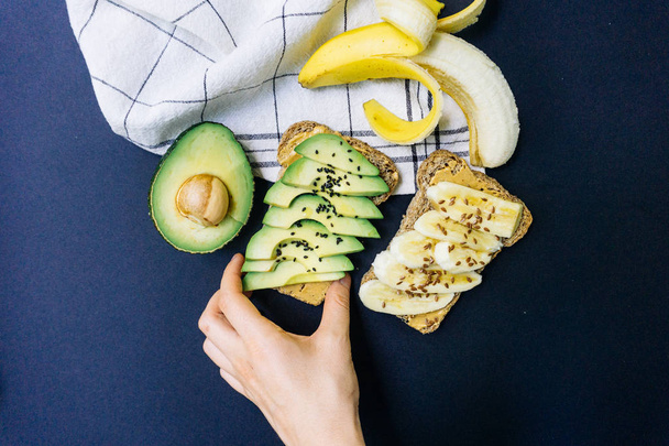 Toast with avocado, sesame and peanut butter on whole grain bread and toast with banana and flaxseed on whole wheat bread - Zdjęcie, obraz