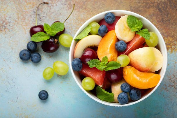 Miska zdravého ovocného salátu na modrém pozadí rezavé. Pohled shora. - Fotografie, Obrázek