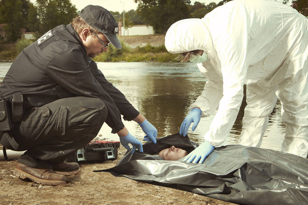 Woman found drowned on river bank in city placed in body bag for transportration - Foto, Bild