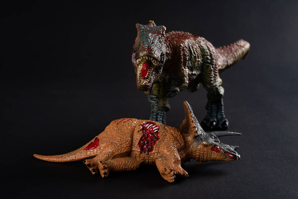 Tyrannosaurus mit einem Triceratops-Körper in der Nähe auf dunklem Hintergrund - Foto, Bild