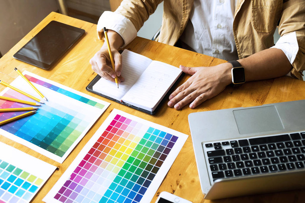 I progettisti grafici scelgono i colori dai campioni di bande di colore per il design.
 .  - Foto, immagini