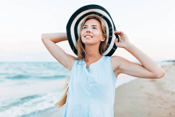 Beautiful portrait of a girl in a hat close-up, rest on the sea or ocean, a woman in a summer blue dress - Foto, Bild