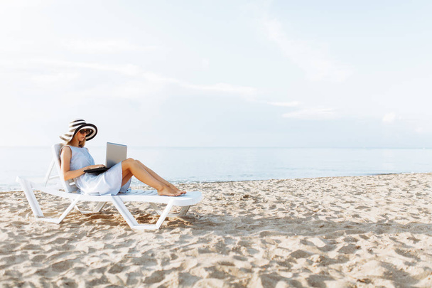 Freelancer girl working on vacation, in front of the beautiful sea - Valokuva, kuva