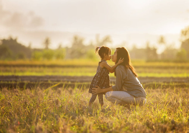 mother and daughter kissing in the field - Foto, immagini
