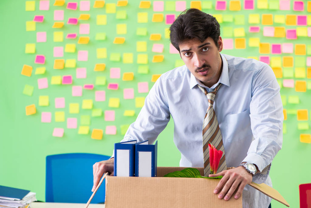 Ο άνθρωπος μαζεύει τα πράγματά του μετά την απόλυση στο γραφείο με τον άνθρωπο - Φωτογραφία, εικόνα