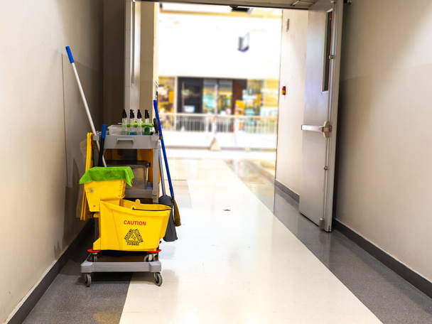 Cleaning tools cart wait for maid or cleaner in the department store. Bucket and set of cleaning equipment in the mall. Concept of service, worker and equipment for cleaner and health - 写真・画像