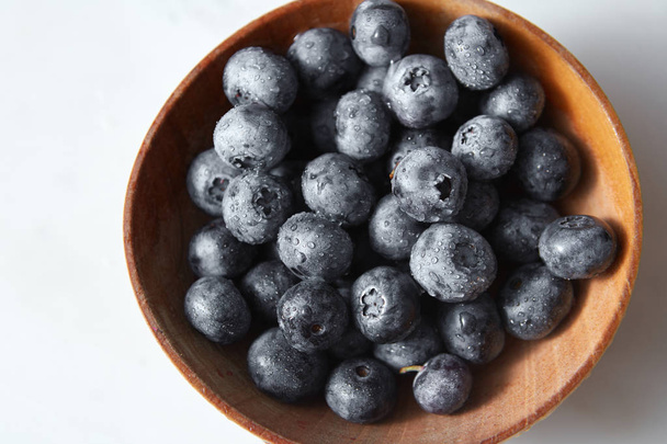 Natural fresh blueberries in bowl. Ingredients for delicious berries - Fotó, kép