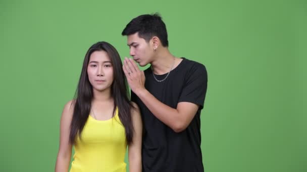 Nuori aasialainen pari kuiskii toisilleen
 - Materiaali, video