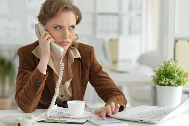 Retrato de una joven empresaria hablando por teléfono en la oficina
  - Foto, Imagen