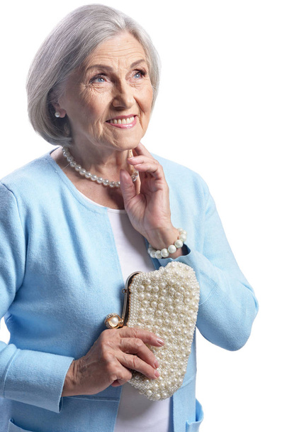 Portrait of beautiful senior woman posing with purse isolated on white background  - Фото, изображение