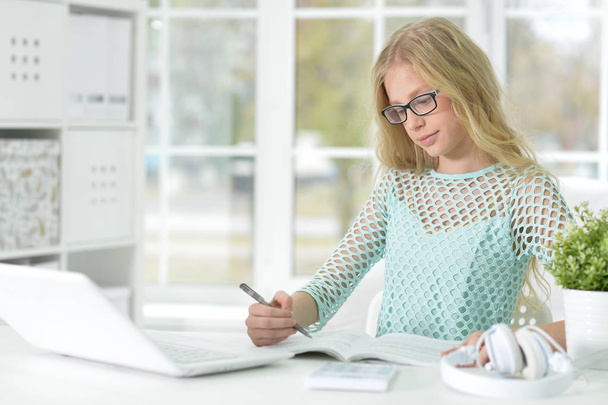 блондинка з ноутбуком навчається за столом
 - Фото, зображення