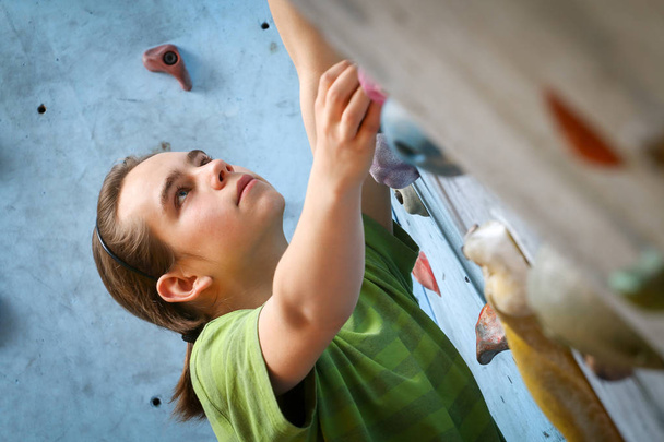 Εφηβικό αγόρι κατάρτισης αναρρίχηση σε εσωτερικός τοίχος αναρρίχησης - Φωτογραφία, εικόνα