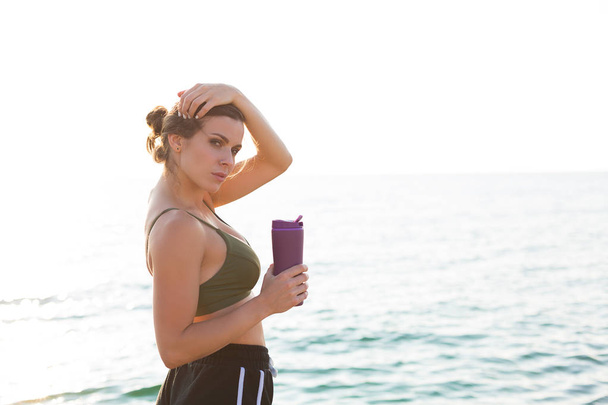 Young woman working out at the beach in the summer - Photo, image