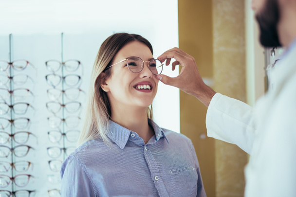 Οφθαλμίατρος κάνει μια οπτική εξέταση ενός πελάτη με ένα οπτικό κέντρο. - Φωτογραφία, εικόνα