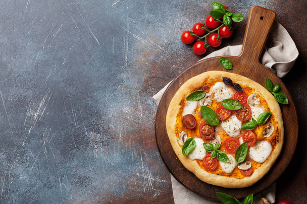 Итальянская пицца с помидорами, моцареллой и базиликом. Вид сверху с пространством для вашего текста
 - Фото, изображение