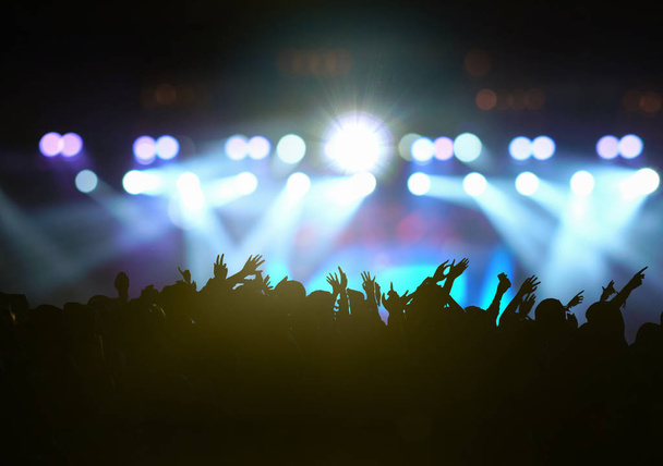 Concert crowd in silhouettes of Music fanclub with show hand action which follow up the songer at the front of stage with follow light, musical and concert concept - Photo, Image