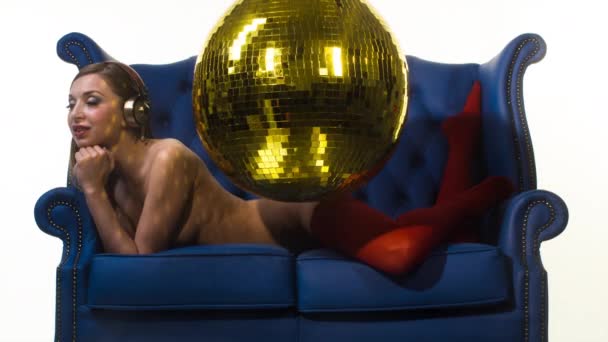 mooie sexy topless vrouw poseren en dansen op een blauwe lederen stoel op witte achtergrond - Video