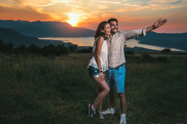 Portrait of young couple on picnic date, beautiful sunset over Boka Bay - Fotoğraf, Görsel