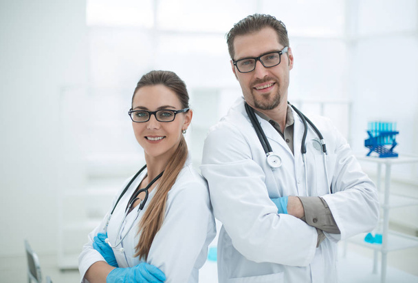 Portret van twee jonge wetenschappers op de achtergrond van het laboratorium - Foto, afbeelding