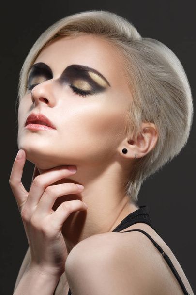 Beauty portrait of blond woman with short haircut on black background. - Fotó, kép