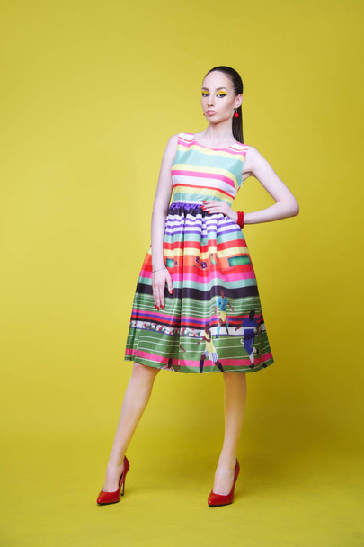 Fashion model in summer dress on yellow background in full growth - Foto, imagen