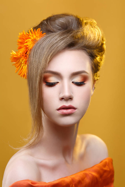 Fashion beauty portrait of girl with orange makeup on yellow background. - Zdjęcie, obraz