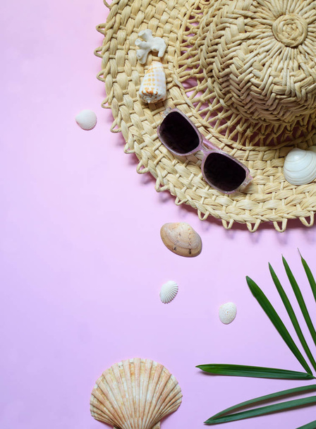 Creative minimal summer idea. Tropical beach concept made of bamboo hat, sunglasses, seashells and green palm leaves on pastel background. Creative art. Flat lay, top view. Copy space. - Photo, image