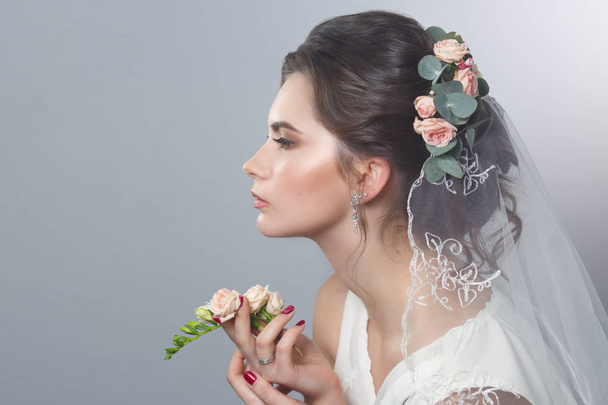 Beauty portrait of innocent bride with veil on gray background. Wedding make up and hair. - Zdjęcie, obraz