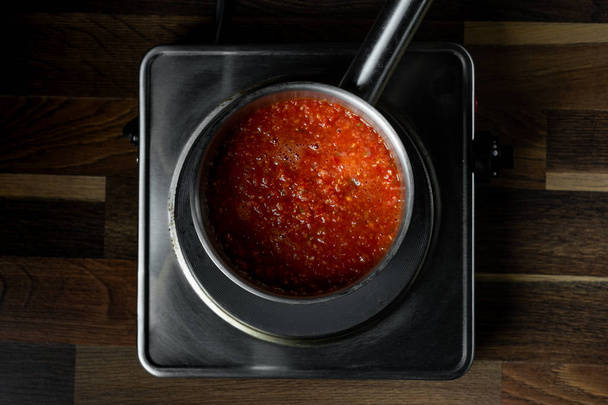 Cooking tomato sauce in metal saucepan, steps process on kitchen on black background copy text recipe. - Fotografie, Obrázek