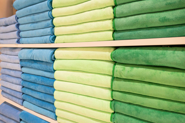 muchas toallas de colores se pliega en estantes en la tienda para las ventas .  - Foto, Imagen
