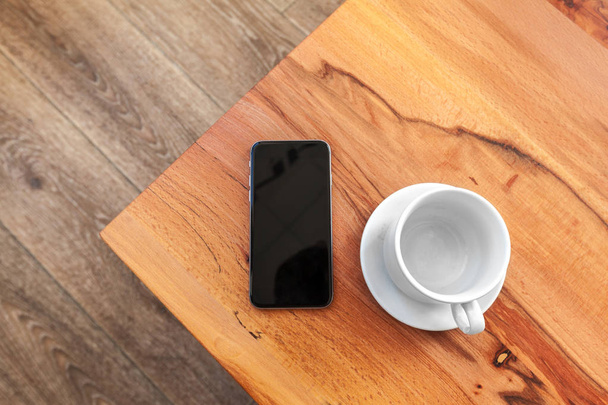 Mobile phone with blank screen mockup on wood table background - Zdjęcie, obraz