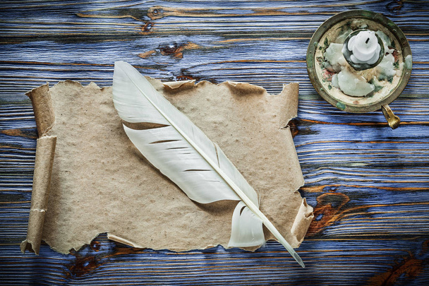 Vintage paper scroll feather candlestick on blue wooden background. - Zdjęcie, obraz