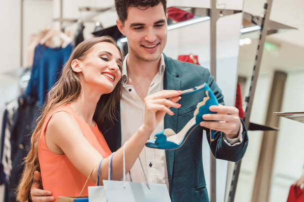 Kobieta z jej mężczyzna ogląda niebieskie buty w sklepie - Zdjęcie, obraz