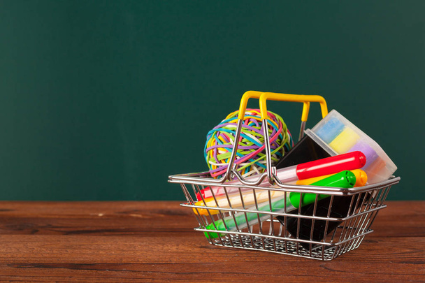 School supplies on a wooden table and blackboard background - 写真・画像