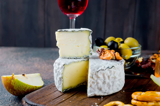 cheese sliced, cheese with mildew, hard cheese, olives, walnuts, peanuts, honey, a glass of wine, a romantic dinner, a meal for the shurman - Foto, Bild