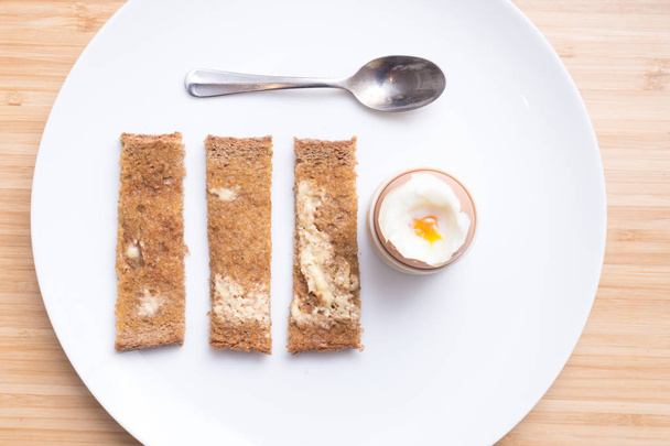 Soft boiled eggs with toast on a white plate. Breakfast - Foto, Bild