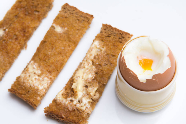 Huevos blandos hervidos con tostadas en un plato blanco. Desayuno
 - Foto, imagen