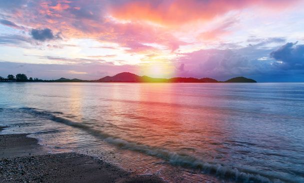 Meri auringonlasku tai auringonnousu värikäs taivas ja pilvi ja auringonvalo hämärässä
 - Valokuva, kuva