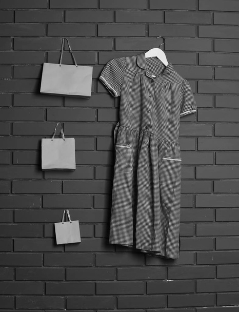 dress and shopping bags on brick wall background - Fotó, kép