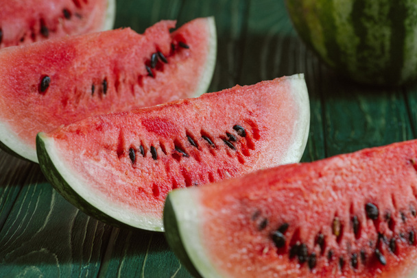 close up view of watermelon slices on green wooden surface - Photo, Image