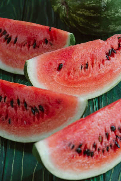 close up view of watermelon slices on green wooden surface - Foto, imagen